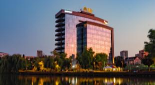 hotel in with lake in front of it at dawn