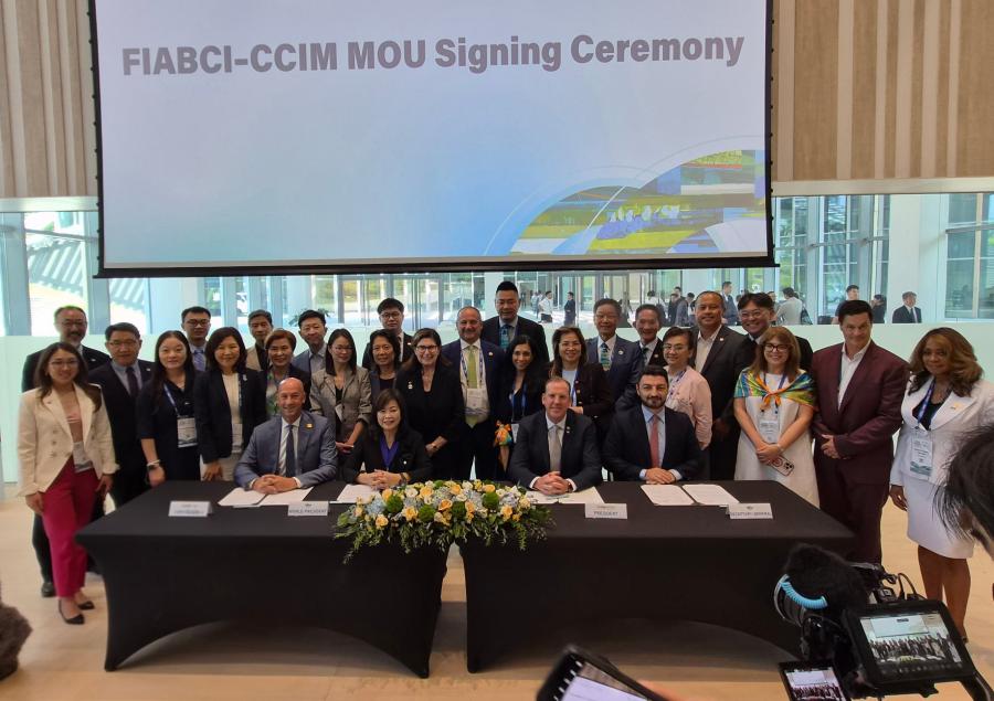 Group of professionals posing behind a conference table during FIABCI-CCIM MOU Signing Ceremony.