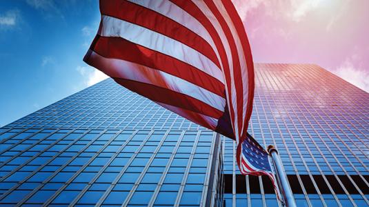 american flag in front of a large office building