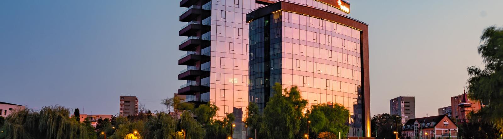 hotel in with lake in front of it at dawn