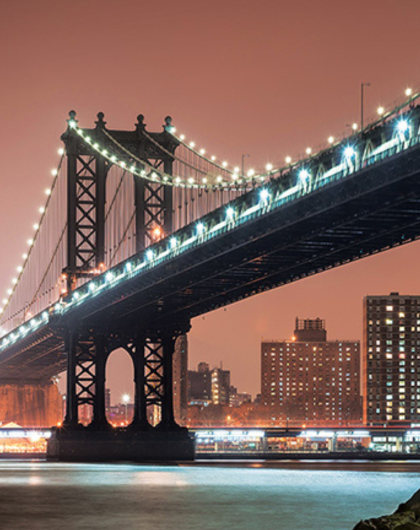 bridge lit up at night in a cityscape